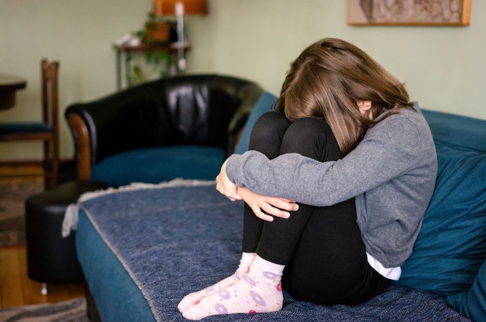 膝を抱えて泣く少女